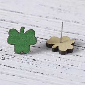Detail des boucles d'oreilles trèfle en bois face verte et tige métallique au dos.