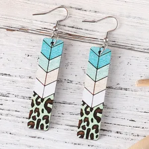 Lange handgefertigte Ohrringe aus Holz mit blauem Zickzackmuster und modischem Leopardenprint.