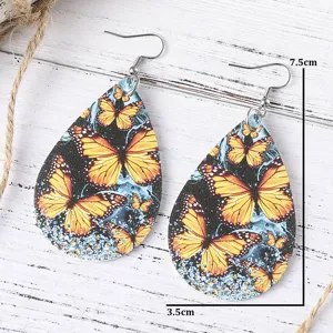 Nahaufnahme von tropfenförmigen PU-Leder-Ohrringen mit Monarch-Schmetterlingsmuster.