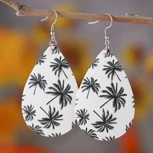 Detailaufnahme der stylischen Tropfenohrringe mit schickem schwarzweißen Palmenmuster.
