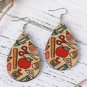 Close-up detail of school theme wooden teardrop earrings with colorful pencil and apple print.