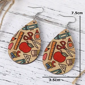 Close-up detail of school theme wooden teardrop earrings with pencil and ruler pattern print.