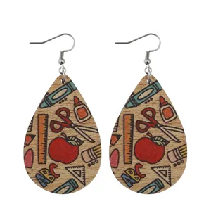 Wooden teardrop earrings featuring school theme prints like pencils and rulers, detailed close-up.