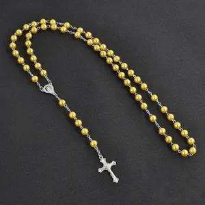 Detailed view of yellow imitation pearl rosary necklace with silver crucifix pendant.