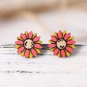 Λεπτομερές κοντινό πλάνο από χαριτωμένα ξύλινα σκουλαρίκια λουλουδιών με ροζ και κίτρινα πέταλα.