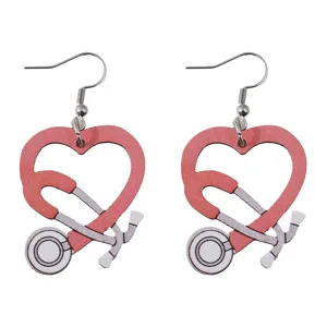 Gros plan des boucles d'oreilles en bois stéthoscope cœur, bijou infirmière tendance.