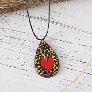 Collar con colgante de lágrima de madera con estampado de leopardo y corazón rojo detalle moda.