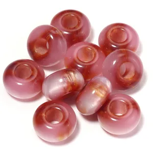 Close-up detail shot of pink and gold resin cat eye loose beads, perfect for DIY jewelry making.