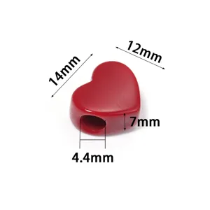 Dettaglio in primo piano di una perla in acrilico rosso a forma di cuore con misure.