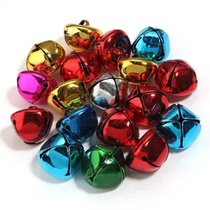 Detailed view of colorful metal jingle bells, cross design, DIY Christmas pet collar craft pendants.