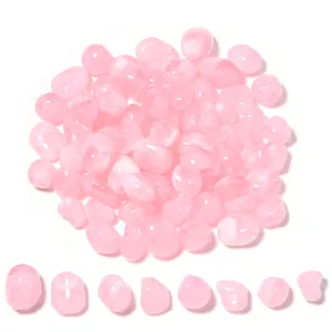 Detalle de cuentas acrílicas rosas irregulares, formas mixtas para hacer joyería artesanal.