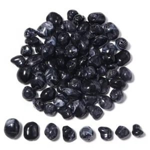 Detalle de cuentas sueltas de acrílico jaspeado en blanco y negro irregular para joyería artesanal DIY.