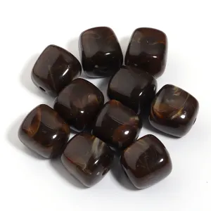 Primer plano de cuentas cuadradas de acrilico marron con patron, ideal para manualidades.