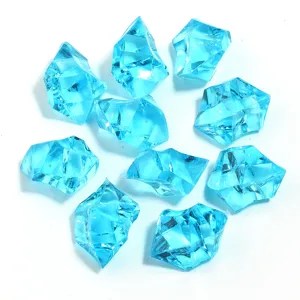Close-up of blue transparent acrylic ice rocks, irregular crystal stones for DIY craft decor.