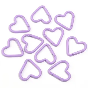 Detail view of light purple heart shaped alloy carabiner spring snap hooks for bags and keys.