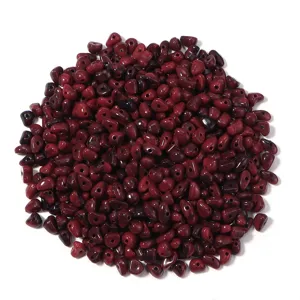 Vue détaillée de perles de rocaille irrégulières en cristal acrylique rouge foncé pour bijoux.