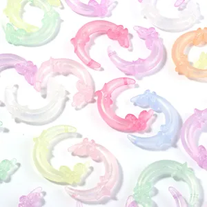 Close-up view of shimmering acrylic crescent moon beads with cute butterfly details, ideal for DIY.