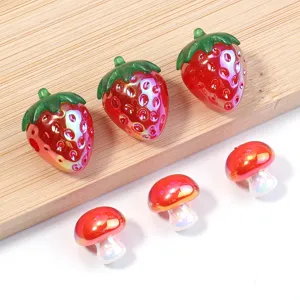 Close up of colorful acrylic strawberry and mushroom beads for DIY jewelry making and charms.