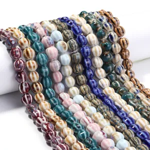 Detailed view of colorful glazed ceramic striped pumpkin beads, perfect for DIY jewelry making.