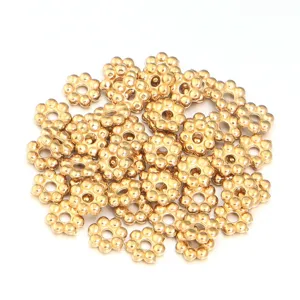 Close-up detail of golden flower metal spacer beads, perfect for DIY handmade jewelry crafts.
