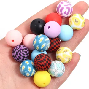 Primer plano de cuentas de silicona DIY coloridas con motivos de margaritas y cuadros para joyas.