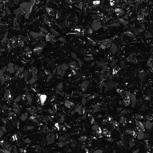 Primer plano de partículas de vidrio triturado negro, ideal para micropaisajes y manualidades.
