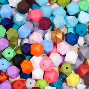 Gros plan de perles en silicone geometriques colorees, ideales pour bracelets DIY et accessoires.