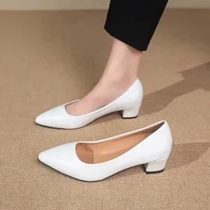 Detail shot of elegant white pointed toe block heel pumps showcasing clean design and fit.