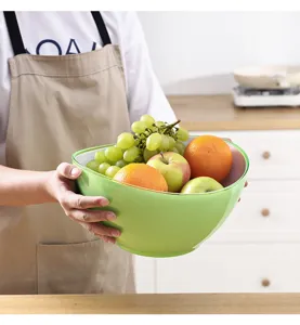 Vue détaillée du saladier en plastique bicolore rempli de fruits frais dans une cuisine propre.