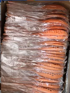 Vue detaillee de la grande ecumoire de cuisine en nylon orange avec des trous de drain.