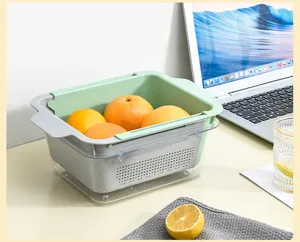 Detailed view of adjustable sink colander basket filled with fresh fruits on clean desk scene.