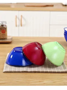 Vue détaillée de bols à salade et de corbeilles de fruits en plastique au design translucide.