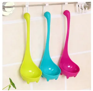 Vue détaillée de louches à soupe Nessie colorées suspendues proprement sur un mur de carrelage.