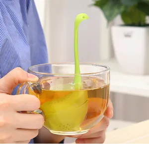 Détail d'infuseur à thé monstre du Loch Ness en plastique vert, ustensile de cuisine mignon.