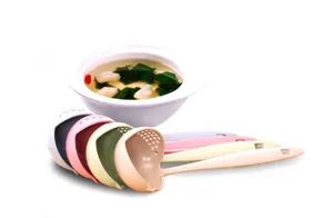 Detail view of wheat straw long-handled soup spoon and colander, showing multi-color design.