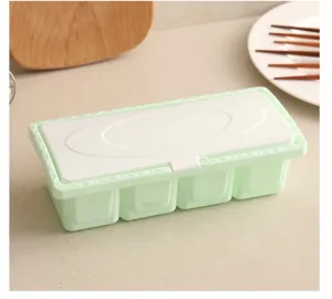 Four-grid plastic spice box set with dustproof lids for kitchen seasoning storage.