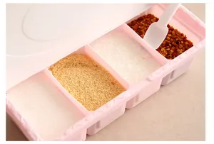 Detail shot of a four-compartment plastic seasoning box with spoons and dustproof lid.