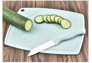 Close-up detail showcasing a sharp white ceramic fruit knife and blue cutting board with fresh cucumber.
