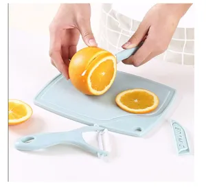 Ceramic fruit knife set with cutting board and peeler for kitchen use in light blue.