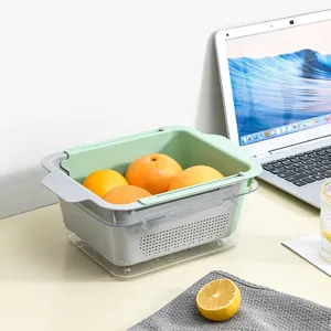 Retractable kitchen sink colander basket for washing fruit and vegetables, grey and green.
