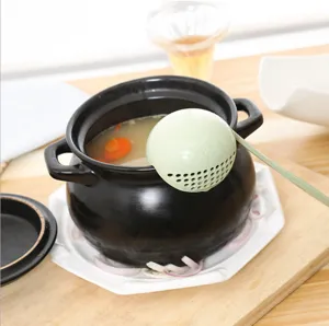 Wheat straw long-handle soup ladle and strainer spoon, shown in use in a black pot.