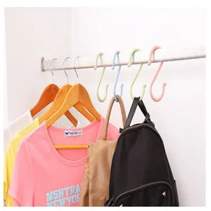 Crochets en S en plastique colorés suspendus sur une tringle avec des vêtements et des sacs.