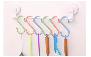 Vue détaillée de crochets en S en plastique coloré suspendus sur une barre ventouse.