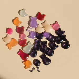 Detailopname van kleurrijke hars kattenbedels met glitterpoeder en schattige staartaccessoires.