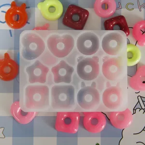 Clear silicone mold for DIY resin jewelry, features cute bear, bunny, heart and donut shapes.