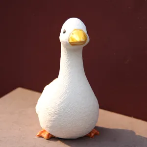 Detailed close-up shot of a cute white goose figurine with orange beak, perfect home decor.