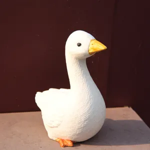 Close-up view of white goose figurine detail, featuring textured resin ornament surface.