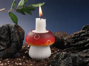 Mushroom shaped candle holder detail shot with burning candle, resin ceramic decor and nature prop.