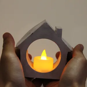 Detail shot of a creative house shaped candle holder with warm LED light for home decor.