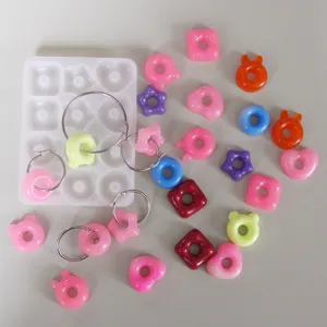 Close-up of colorful resin cute donut and animal charms with hoop earrings and silicone mold.
